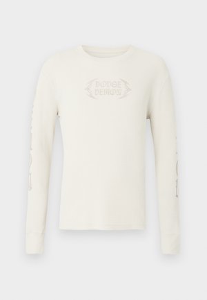 Långärmad creamfärgad ribbad T-shirt med "DODGE DEMON" broderat på framsidan och tryck på höger ärm. Mjuk textur.