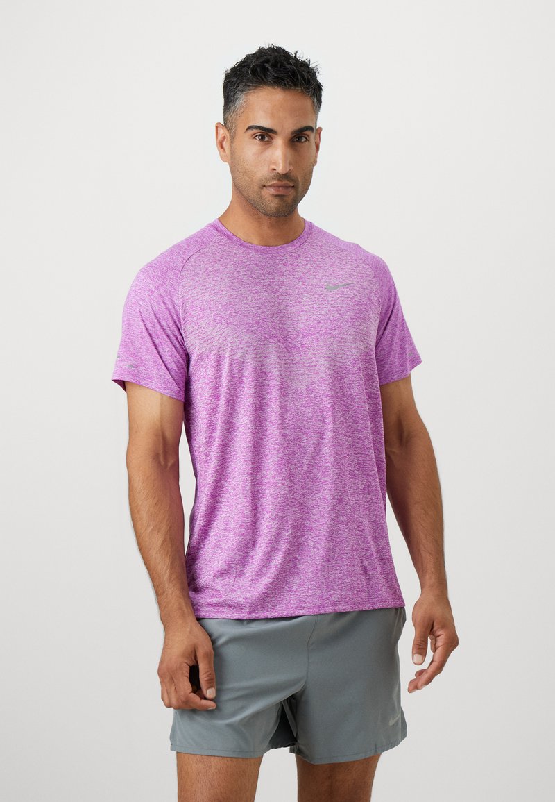 Lila Sport-T-Shirt mit strukturiertem Muster, kurzen Ärmeln und rundem Ausschnitt. Verfügt über ein kleines reflektierendes Logo auf der oberen Brust.