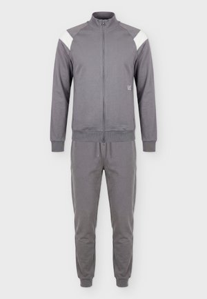 Męska szara bluza dresowa na całej długości na zamek z białymi akcentami na ramionach oraz pasujące spodnie dresowe z ściągaczem.