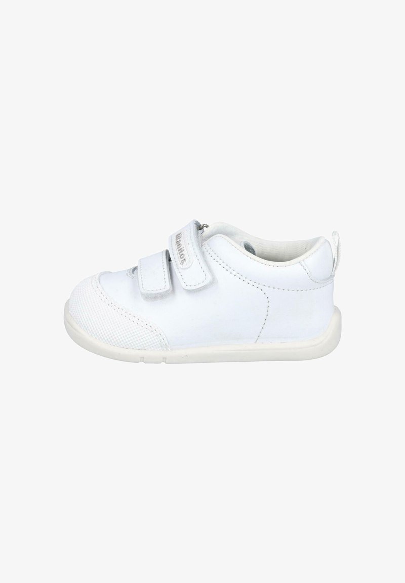 Zapatilla blanca para niños con puntera texturizada, dos tiras de velcro y cuello acolchado. Material superior liso y suela de goma.