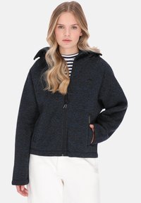 Jachetă din fleece albastru închis cu fermoar frontal, două buzunare laterale și glugă. Prezintă o textură moale și un model discret pistruiat.