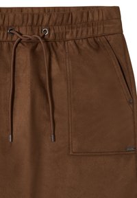Pantalons de sport marron avec une taille élastique, cordon de serrage, poches latérales et texture lisse et douce. Présente des accents métalliques aux extrémités du cordon de serrage.