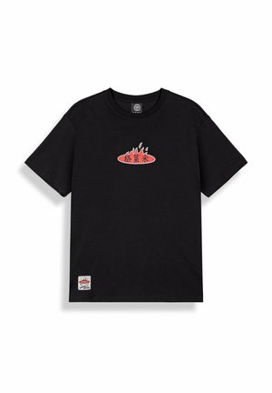 Czarna koszulka z krótkim rękawem z czerwonym owalnym logo i wzorem płomienia na piersi oraz małą białą prostokątną łatką przy dolnym brzegu.