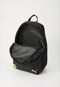 Schwarzer Rucksack aus robustem Material, mit einem Reißverschluss-Hauptfach und einem strukturierten Muster, verziert mit einem gelben Logo und Akzenten.