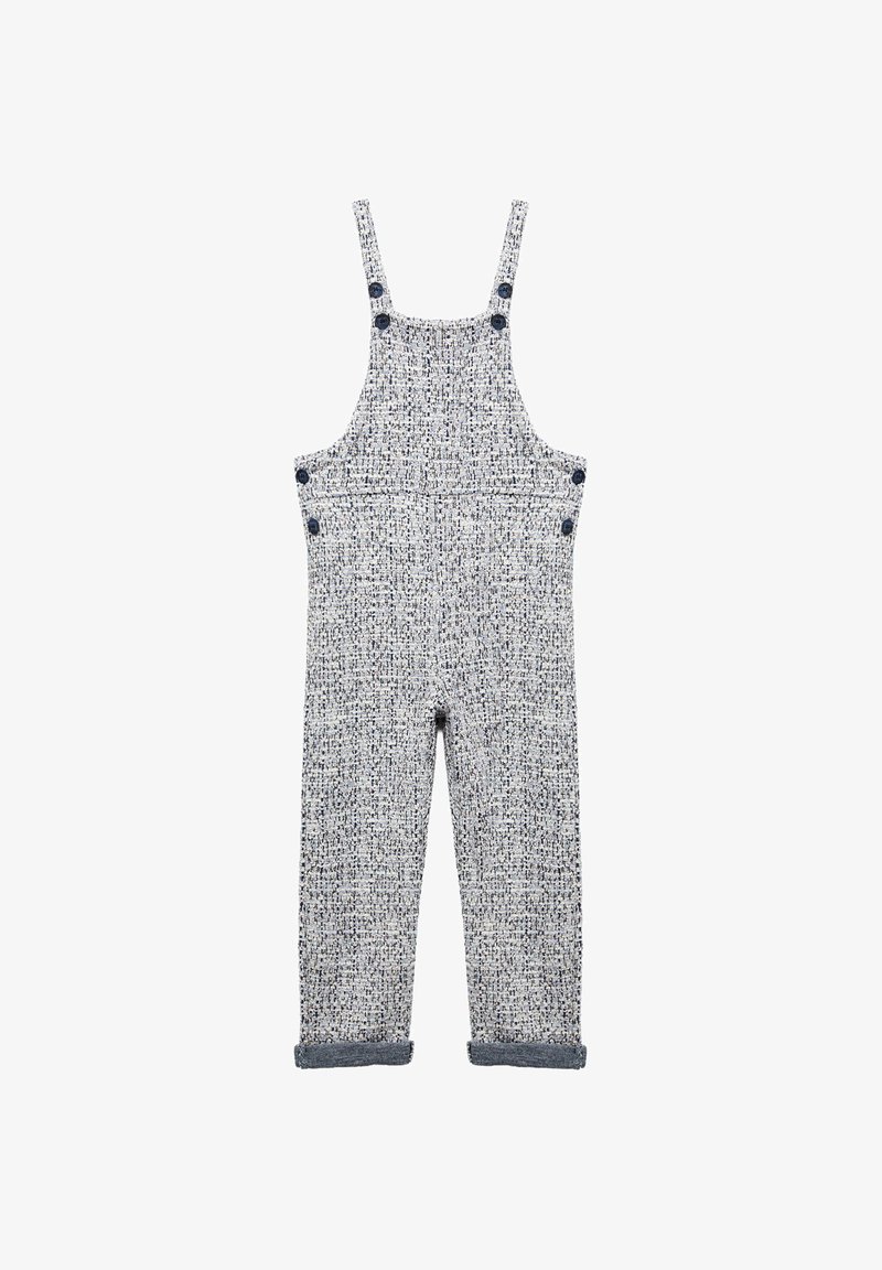 Salopette a pattern blu e bianco con spalline, tasche frontali e orli arrotolati. Realizzata in un tessuto tessuto testurizzato.