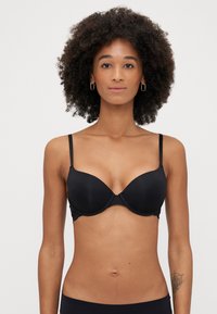Reggiseno push-up nero con coppe modellate lisce, spalline sottili e regolabili, e dettagli in pizzo lungo il bordo. Design semplice e minimalista.