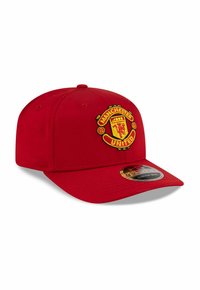 Red cap featuring an embroidered Manchester United logo on the front. The hat has a structured design and a curved visor. Stretch fit.