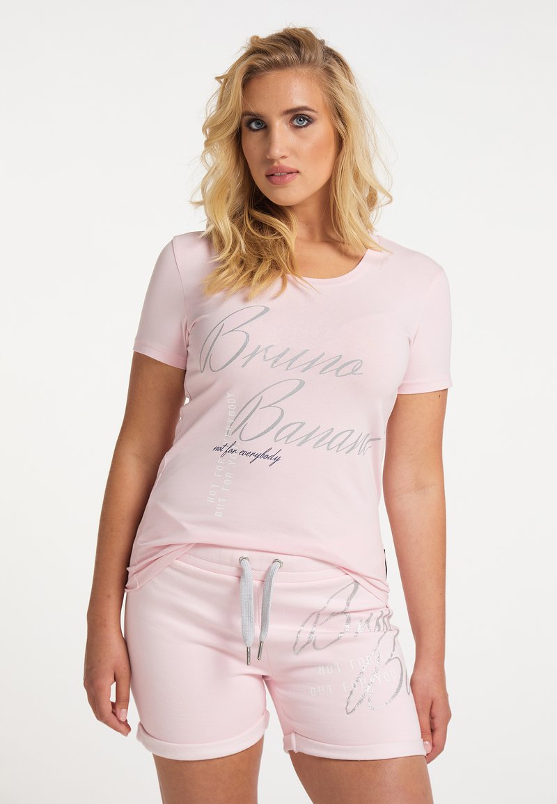 Hellrosa T-Shirt mit kurzen Ärmeln und silbernem Grafiktext, kombiniert mit passenden hellrosa Shorts mit umgeschlagenen Säumen und verstellbarem Bund.