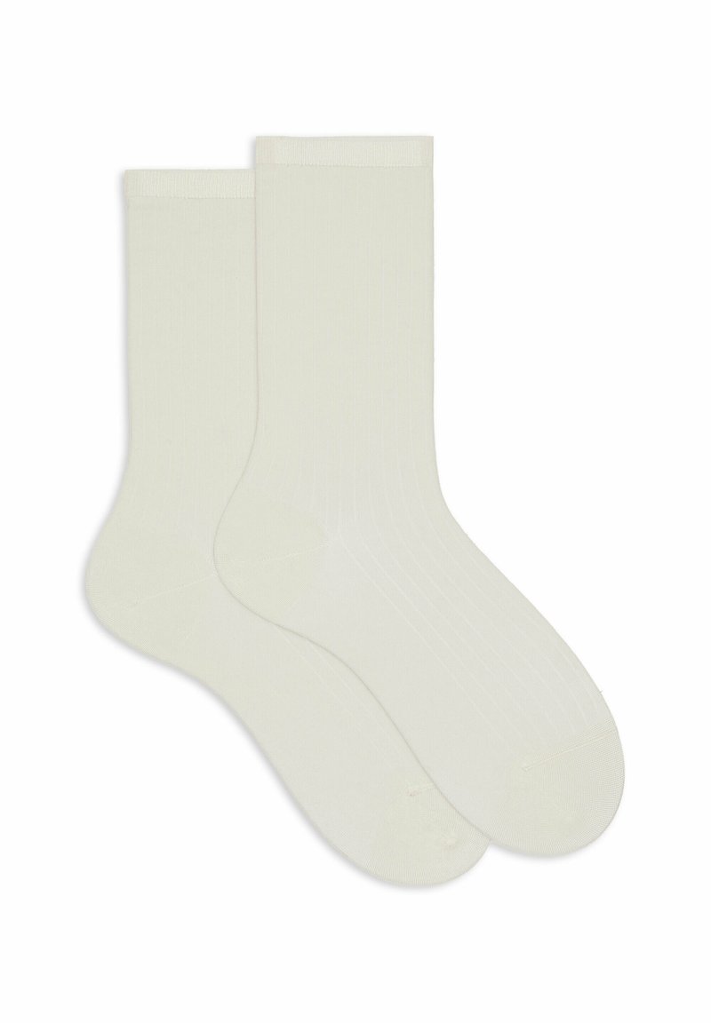 Due calze a coste di lunghezza crew di colore bianco sporco disposte piatte, sovrapposte, con punta rinforzata e polsini elasticizzati.