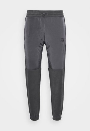 Grijze sweatpants met een geribbelde tailleband, trekkoordsluiting en contrasterende stofstructuur; voorzien van een subtiele logo op de linkerdij.