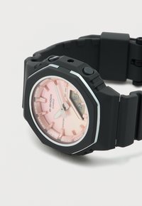 Μαύρο ρολόι χειρός Casio G-Shock με ροζ αναλογικό-ψηφιακό καντράν, ασημί δείκτες ώρας και μαύρο λουράκι από ρητίνη.