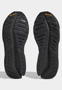 Black rubber shoe soles with a textured surface and intricate tread pattern; features "Continental" logo in yellow at the heel.