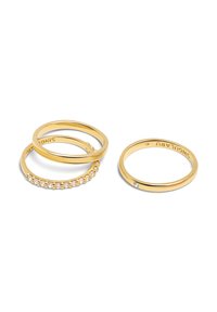 Conjunto de tres anillos de oro: dos bandas lisas y uno adornado con gemas transparentes, con un diseño minimalista y acabado pulido.