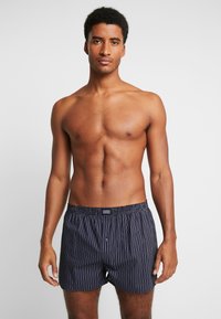 Blauwe gestreepte boxershorts met een elastische tailleband en een knoopdetail aan de voorkant. Gladde stofstructuur; lichtgewicht en ademend ontwerp.