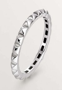 Anillo de plata con una superficie decorada con acentos piramidales, bordes lisos y un diseño abierto con recortes cuadrados en el interior.