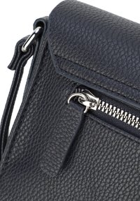 Borsa a tracolla in pelle dettaglio blu scuro con chiusura a pattina e hardware in argento. Presenta una tasca con zip e una tracolla removibile per un'ulteriore versatilità.