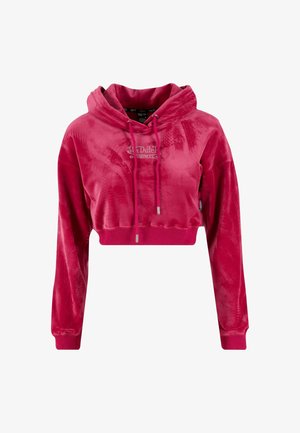 Crop hoodie i lys pink, lavet af et blødt, fløyelsagtigt materiale. Har en justerbar hætte og et logo-accent i rhinsten.