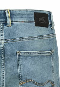 Lichtblauwe denim jeans met een zwart etiket met "Camel Active." Opvallende stiksels en een ontwerp met standaard achterzakken.