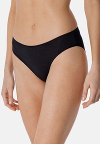 Zwarte bikini slipjes met een ribbelstructuur, voorzien van een medium-rise snit en gestikte details langs de randen voor een stevige pasvorm.