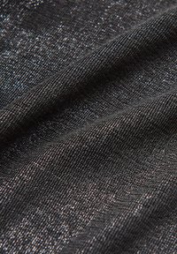 Tessuto nero strutturato con una superficie lucente, caratterizzato da un delicato motivo intrecciato e filamenti metallici per un maggiore interesse visivo.