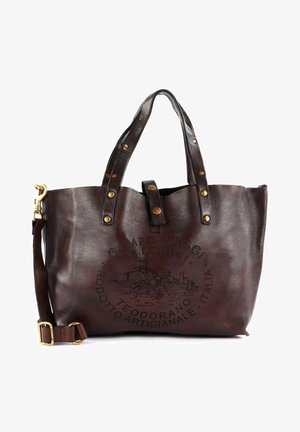 Borsa tote in pelle marrone con superficie testurizzata, dettagli in hardware dorato e un design stampato che presenta un logo di castello sulla parte anteriore.