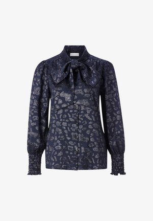 Navy blouse with leopard print, featuring a bow tie collar, button front, and smocked cuffs. Made of a textured fabric with sheen.