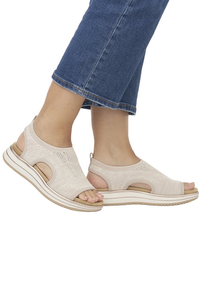 Beige knitted sandals featuring open-toe design, elastic straps, and cut-out details. Thick sole with a textured bottom for grip.