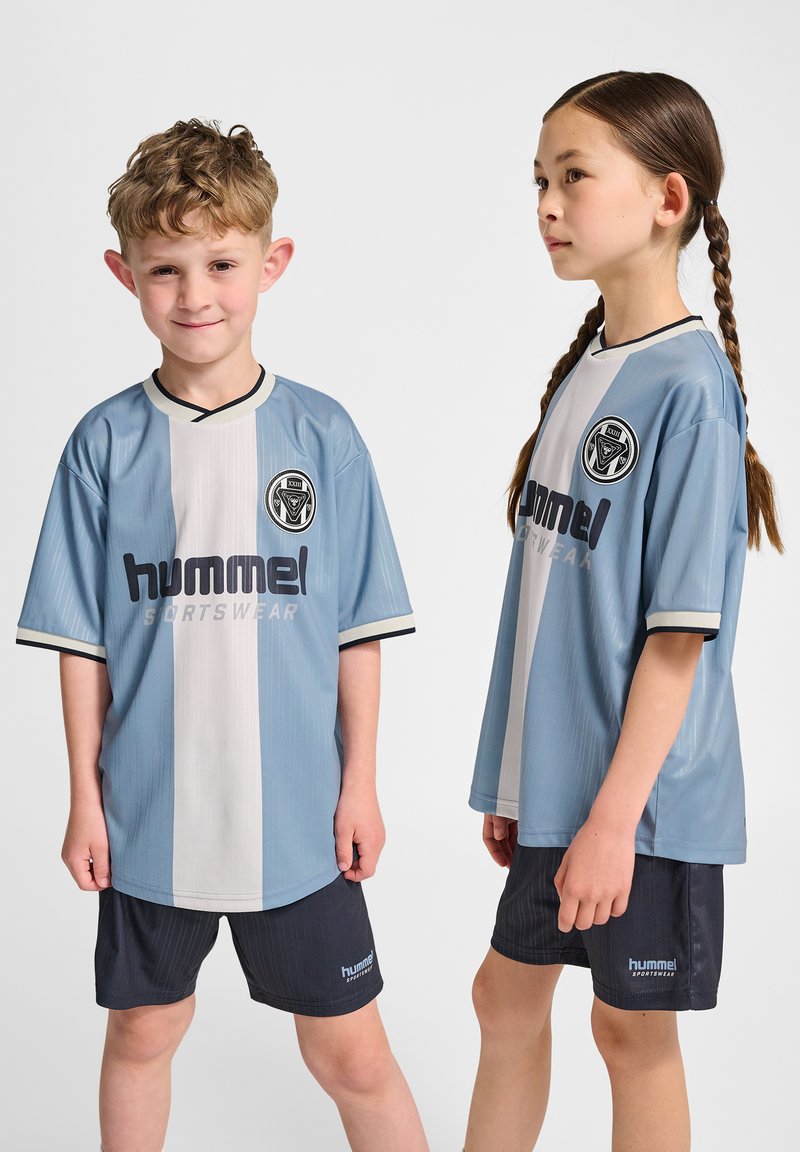 Ljusblå och vita sporttröjor med korta ärmar och svart kantning, med "hummel"-logotypen och kombinerade med mörka shorts.