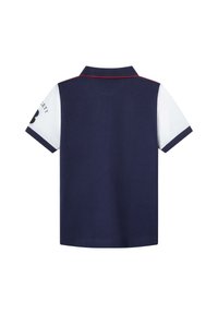 Polo shirt navy avec des manches courtes blanches, col côtelé et accent rouge. Présente un logo sur la manche gauche. Tissu en mélange de coton.