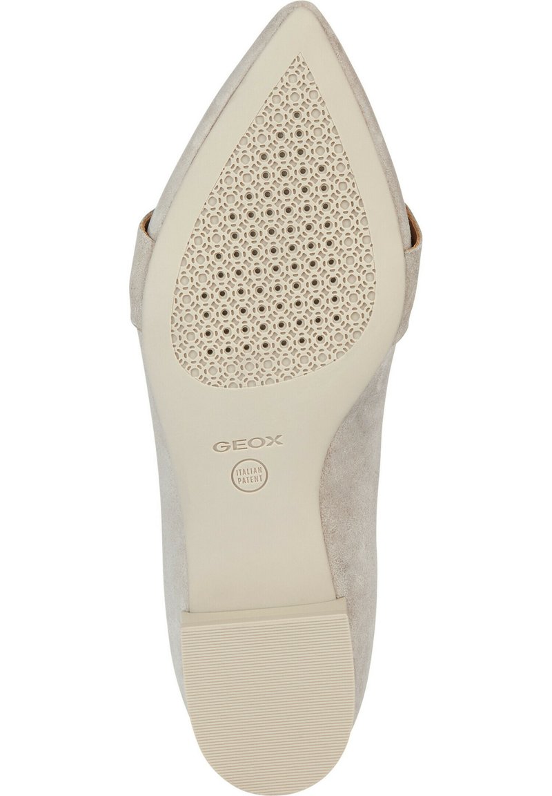 Scarpa décolleté beige in suede con punta affusolata e suola in gomma perforata. Presenta il logo del marchio al centro della suola, che indica il brevetto italiano.
