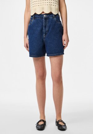 Denim shorts in dark blue with a high waist, five-pocket design, and cuffed hems; paired with a light cream textured top and black flats.