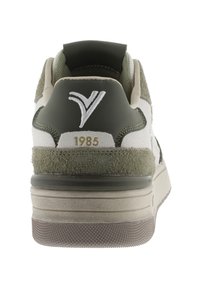 Sneaker verde e bianco realizzata in suede e pelle, con un collare imbottito, logo in rilievo e suola in gomma testurizzata. Modello dell'anno 1985.