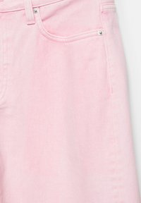 Tissu en denim rose clair montrant une poche avant, une passants de ceinture et des rivets argentés sur un pantalon ou une jupe.