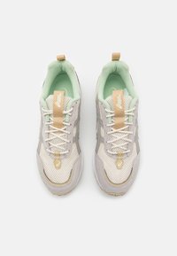 Beige nät-sneakers med mintgröna detaljer, krämfärgade snören och gulddetaljer. Har en strukturerad sula och en broderad logotyp på tungan.