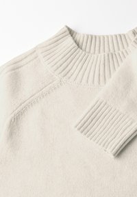 Lichtbeige trui met een geribde funnelneck en boorden, zachte textuur en naadloos ontwerp met een ontspannen pasvorm.