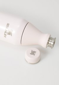 Botella de agua aislada STANLEY en rosa pálido mate, con base de acero inoxidable y tapa atornillable adjunta con acento de logotipo.