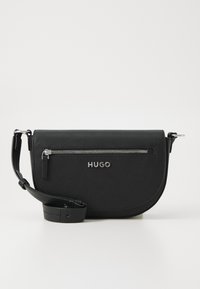 Borsa a tracolla in pelle nera con forma tondeggiante, tasca con zip argento e logo del marchio. Presenta una tracolla regolabile per maggiore versatilità.