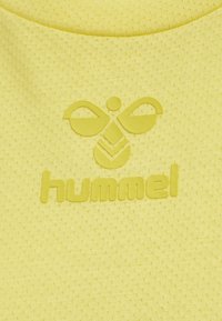 Żółta tkanina o fakturze z wypukłym logo Hummel, przedstawiającym stylizowaną pszczołę oraz nazwę marki w dopasowanym żółtym kolorze.