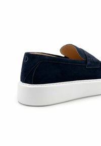 Navy suède instapper met een witte rubberen zool. Voorzien van een gestikte accent en een gladde binnenafwerking.
