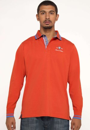 Polo à manches longues rouge avec un col à rayures bleues contrastantes, logo brodé et accents bleus sur les poignets.