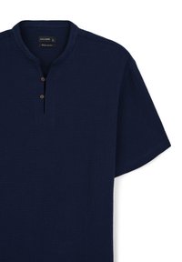 Marineblauses Hemd mit kurzen Ärmeln aus strukturiertem Stoff, einem Stehkragen und drei braunen Knöpfen am Hals.