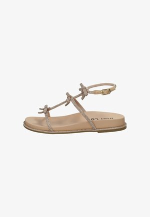 Sandalo piatto beige con sottili cinturini, tre piccoli fiocchi, fibbia alla caviglia e suola imbottita, mostrato dal lato esterno su sfondo bianco.