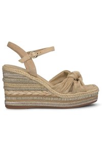 Sandales compensées beiges avec un devant noué, des sangles en cuir et des détails en espadrille tressée. Présente une semelle texturée et des accents métalliques.