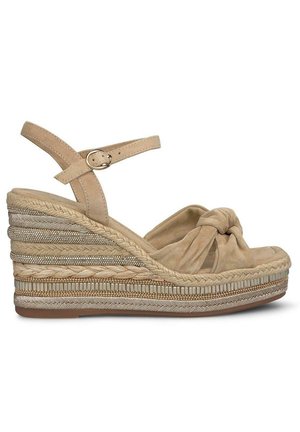 Beige wedge sandals with a knotted front, leather straps, and braided espadrille detailing. Features a textured sole and metallic accents.