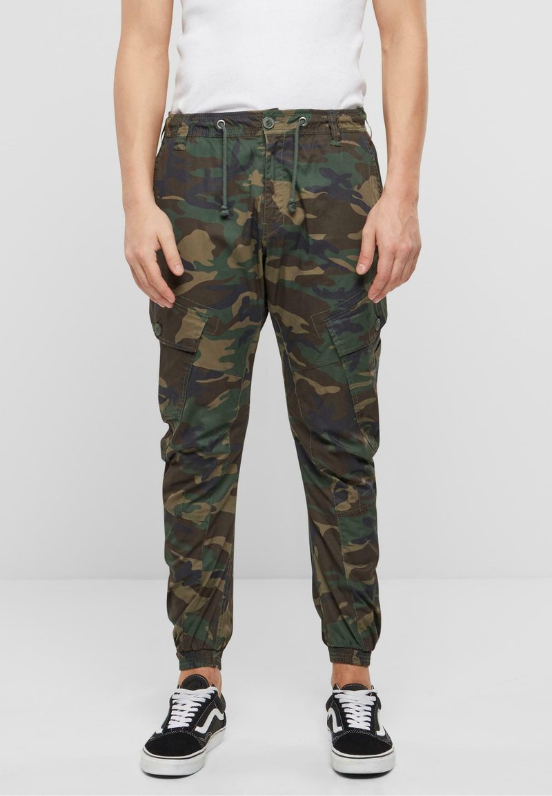 Pantalones jogger de camuflaje en tonos verdes y marrones, con cintura elástica, cordón ajustable, bolsillos tipo cargo y puños ajustados.