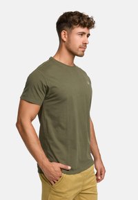Olive green short-sleeve t-shirt made of cotton, featuring a crew neck and a subtle logo on the chest. Smooth texture with a fitted shape.