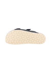 Zapato negro con parte superior texturizada y tiras de Velcro, que presenta una suela de goma blanca con un patrón de panal.