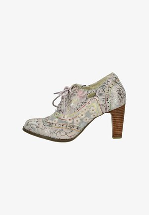 Chaussure à talons pour femme lacée avec motif floral, ornée de marguerites brodées et talon en bois empilé, étiquette de la marque Laura Vita visible.