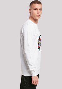 Hvid sweatshirt med et rundt grafisk tryk, der viser farverige tegneserie-billeder. Lange ærmer, ribbede manchetter og rund halsudskæring.