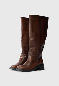 Brązowe skórzane buty za kolano z okrągłym noskiem, gładką teksturą i szerokim obcasem, z minimalną ilością szwów i eleganckim wzornictwem.